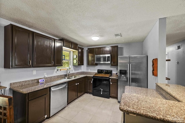 kitchen featuring visible vents, a sink, appliances with stainless steel finishes, and dark brown cabinetry