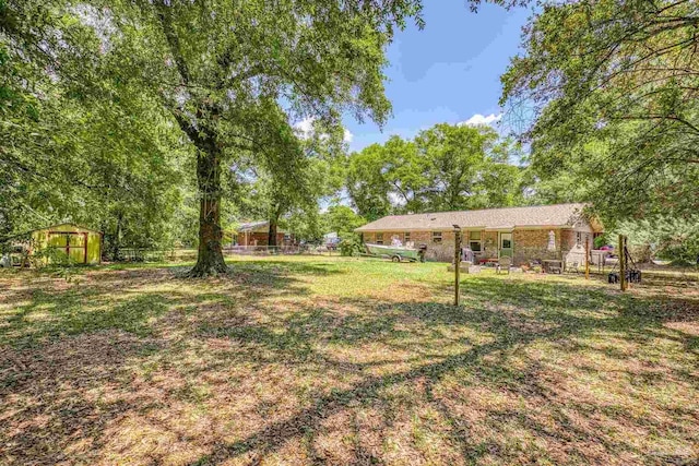 view of yard with fence and an outdoor structure