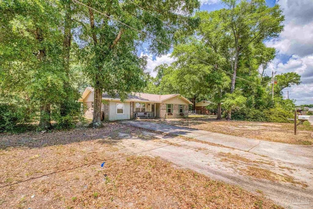 ranch-style house with a porch and driveway