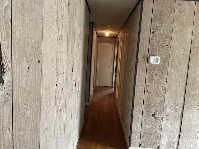 hallway featuring wood finished floors and wood walls