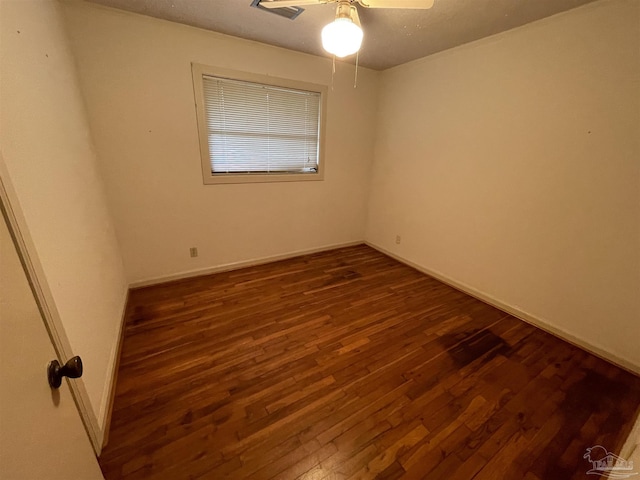 empty room with baseboards, dark wood-style floors, and a ceiling fan