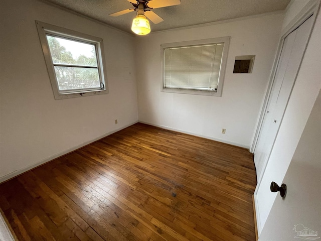 unfurnished bedroom with a closet, a textured ceiling, baseboards, and wood-type flooring