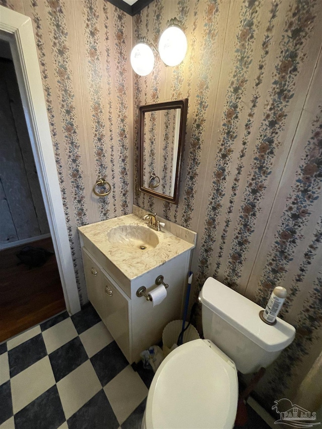 bathroom with tile patterned floors, toilet, vanity, and wallpapered walls