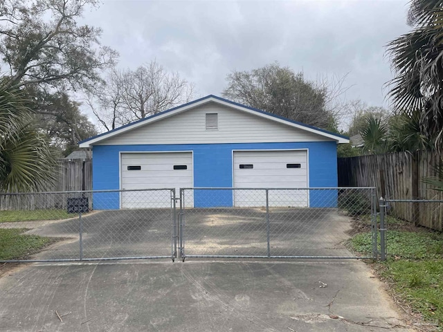 detached garage featuring a gate and fence