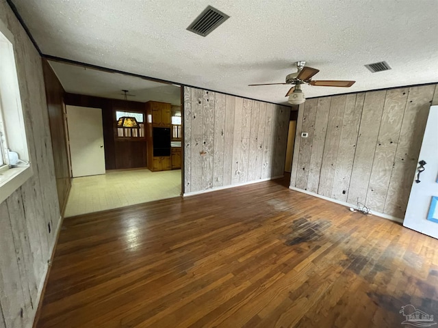 unfurnished living room featuring hardwood / wood-style floors, visible vents, and a textured ceiling