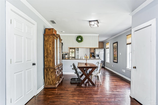 dining space featuring crown molding, baseboards, dark wood-style floors, and visible vents