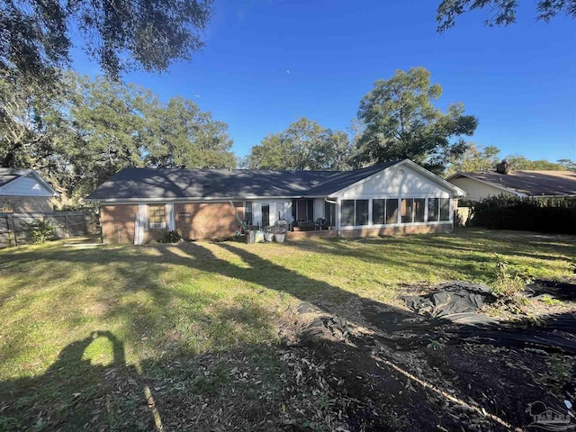 back of house featuring a sunroom and a yard