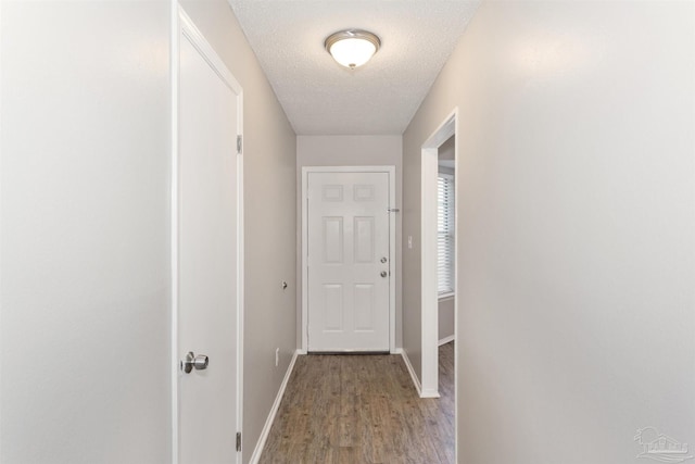 hallway with hardwood / wood-style floors and a textured ceiling