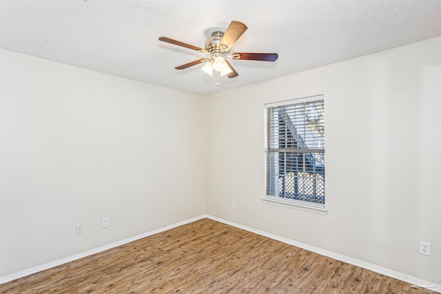 spare room with ceiling fan, wood-type flooring, and a textured ceiling