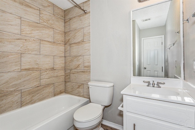 full bathroom featuring a textured ceiling, vanity, tiled shower / bath combo, and toilet