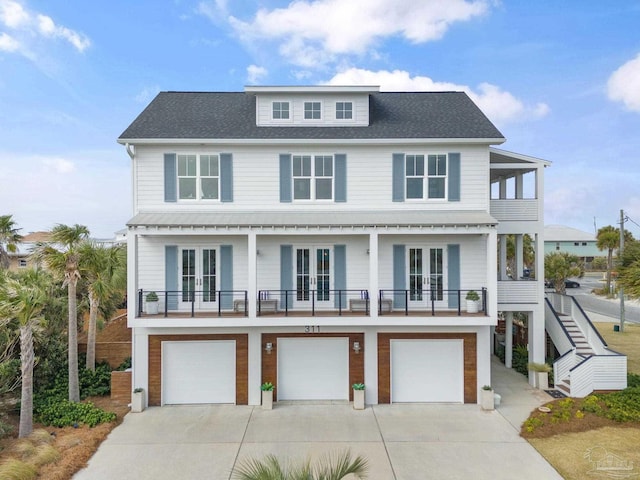 view of front of home with french doors, a shingled roof, a balcony, a garage, and driveway