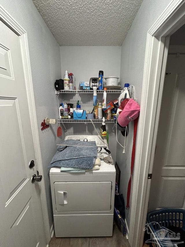 washroom featuring a textured ceiling, laundry area, washer / dryer, and wood finished floors