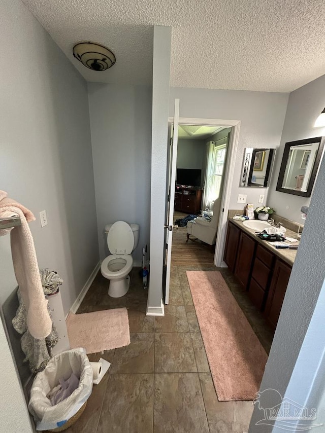 bathroom with vanity, a textured ceiling, and toilet