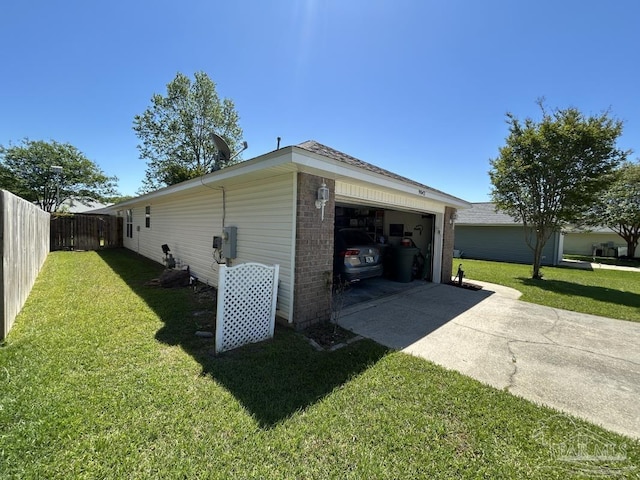 view of side of property with a yard, a garage, brick siding, fence, and concrete driveway