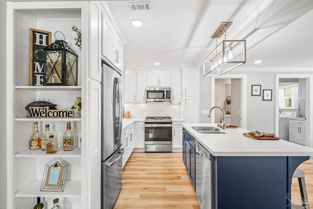 kitchen featuring stainless steel appliances, pendant lighting, sink, and white cabinetry