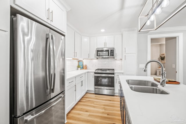 kitchen featuring appliances with stainless steel finishes, sink, light hardwood / wood-style floors, and white cabinets