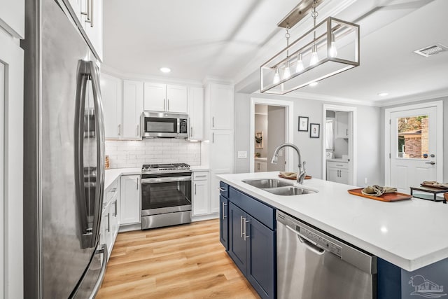 kitchen featuring blue cabinetry, light hardwood / wood-style flooring, sink, white cabinets, and appliances with stainless steel finishes