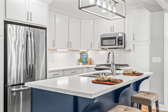 kitchen with hanging light fixtures, a kitchen breakfast bar, white cabinetry, and stainless steel appliances