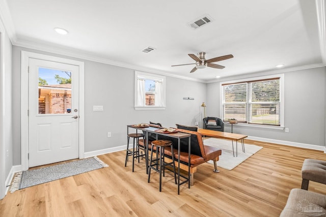 dining space featuring ornamental molding, ceiling fan, and light hardwood / wood-style flooring