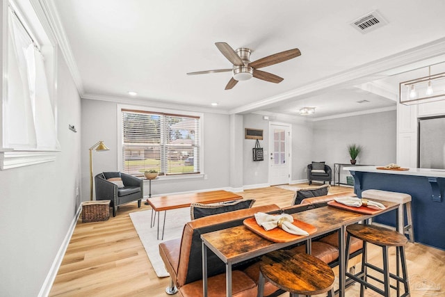 living room with ornamental molding, ceiling fan, and light hardwood / wood-style flooring