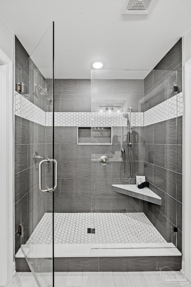 bathroom featuring a shower with shower door