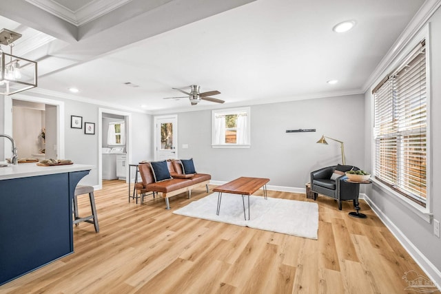 living room featuring ceiling fan with notable chandelier, light hardwood / wood-style floors, beamed ceiling, and ornamental molding