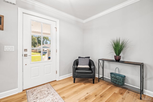 foyer with crown molding and hardwood / wood-style floors