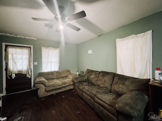 living room featuring ceiling fan, dark hardwood / wood-style floors, and a textured ceiling