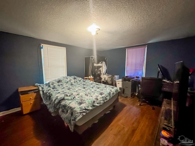 bedroom featuring dark wood-type flooring and a textured ceiling