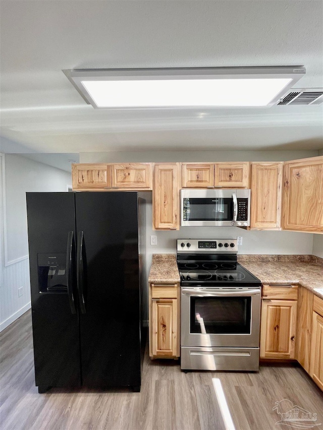 kitchen featuring light brown cabinets, light hardwood / wood-style flooring, and stainless steel appliances