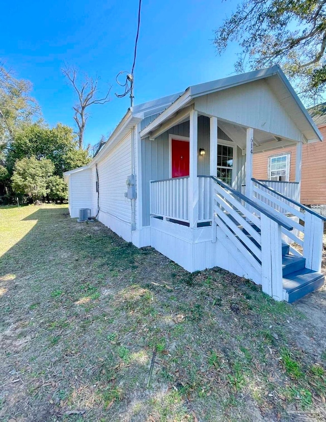 view of home's exterior with a porch, central air condition unit, and a yard