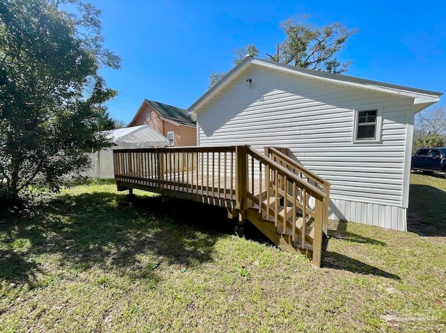 rear view of house with a deck and a lawn