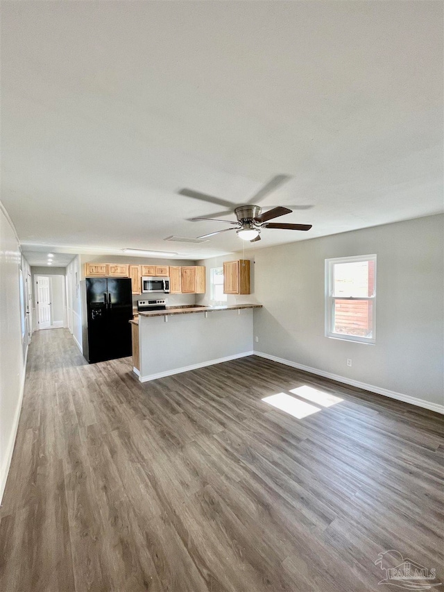 unfurnished living room with wood-type flooring and ceiling fan