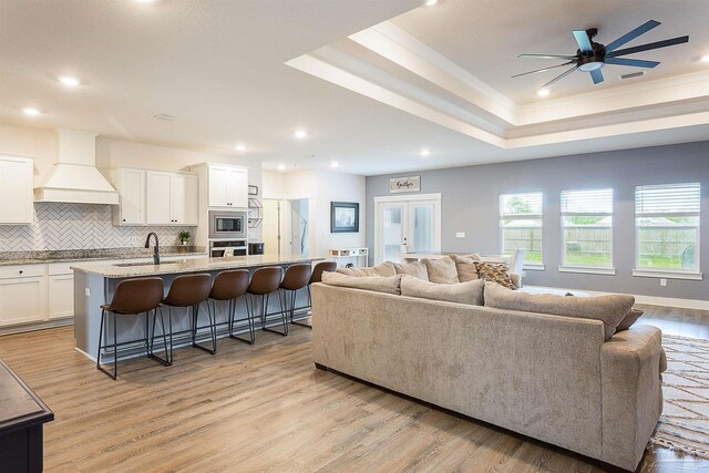 3564 Sailfish Dr, Gulf Breeze, FL 32563 - living room with a tray ceiling, light wood-type flooring, ceiling fan, recessed lighting, and crown molding