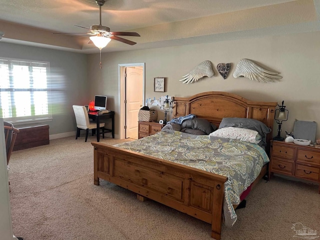 bedroom featuring light colored carpet, a desk, a ceiling fan, and baseboards