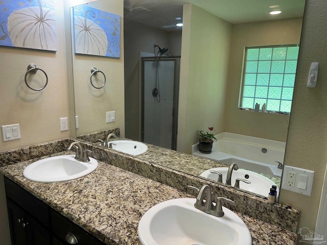 bathroom with a shower stall, a garden tub, and double vanity