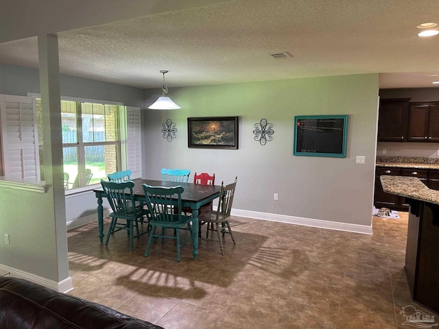 dining room with baseboards, a textured ceiling, and recessed lighting