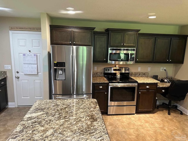 kitchen with appliances with stainless steel finishes, dark stone counters, dark brown cabinets, recessed lighting, and baseboards