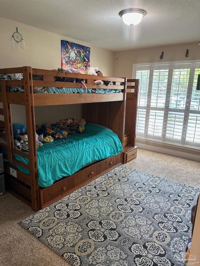 carpeted bedroom with multiple windows and a textured ceiling