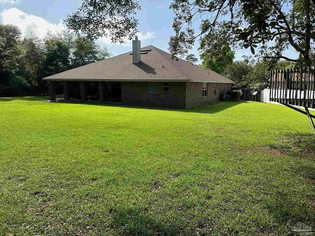 back of property featuring a chimney and brick siding