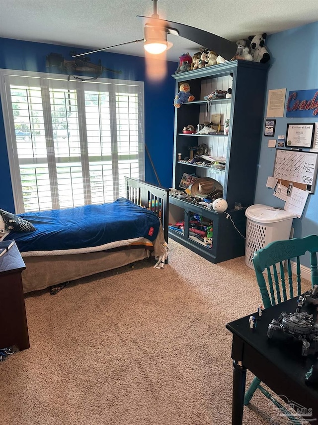 bedroom with carpet, a textured ceiling, and a ceiling fan