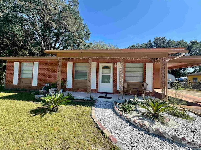 view of front of house featuring a carport, a front lawn, and covered porch