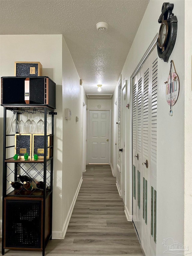 hall with a textured ceiling and hardwood / wood-style flooring