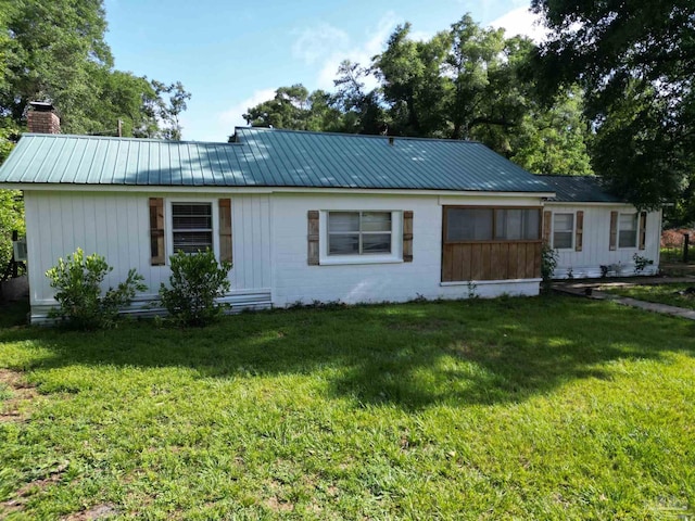 1159 Twin Bridges Rd, Flomaton, AL 36441 - view of front of house with a front lawn, a chimney, a metal roof, and board and batten siding