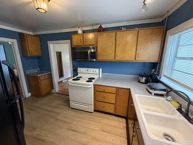 1159 Twin Bridges Rd, Flomaton, AL 36441 - kitchen featuring electric range, stainless steel microwave, brown cabinets, light countertops, and freestanding refrigerator