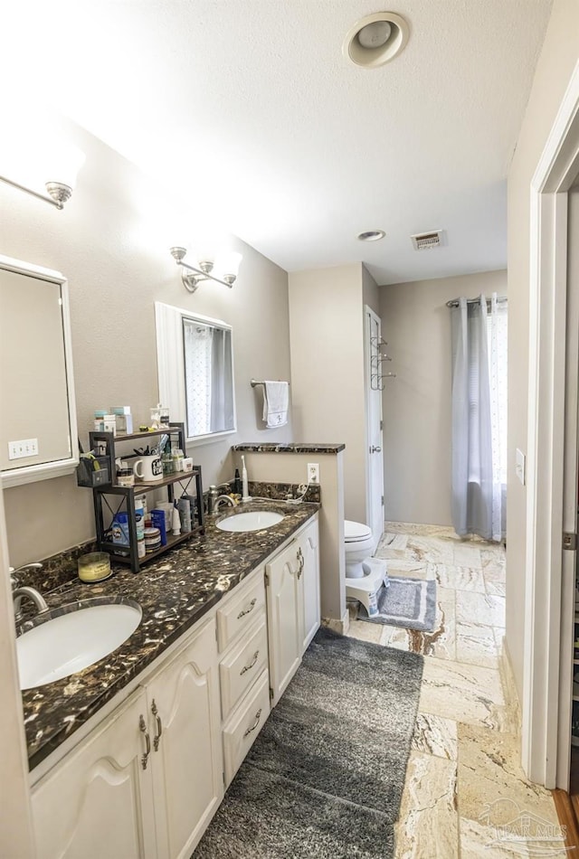 5013 Roland Rd, Pace, FL 32571 - full bath with double vanity, stone tile flooring, and a textured ceiling