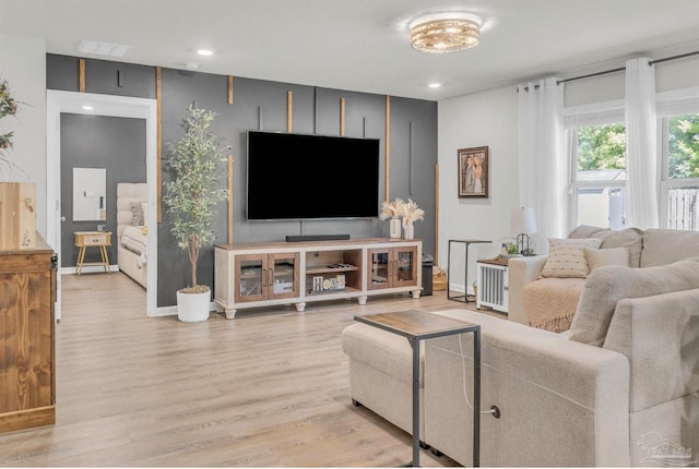 living room featuring visible vents, baseboards, recessed lighting, and wood finished floors