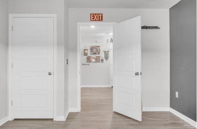 hall featuring baseboards and light wood finished floors