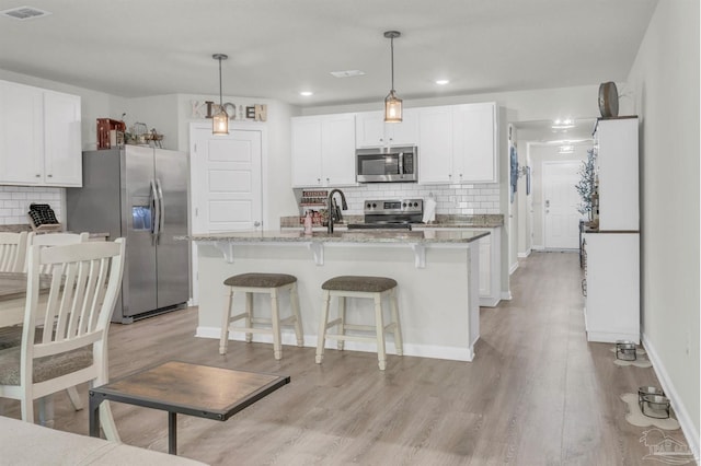 kitchen with tasteful backsplash, visible vents, white cabinetry, and appliances with stainless steel finishes