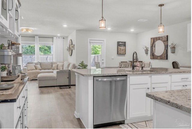 kitchen with a sink, stainless steel dishwasher, pendant lighting, and white cabinets